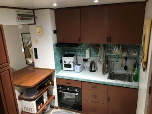 a small kitchen with brown cabinets and a sink at StayinManila in Pasig
