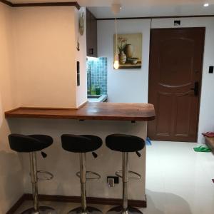 a kitchen with a counter with stools under it at StayinManila in Pasig