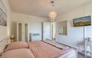 1 dormitorio con cama y lámpara de araña en Amazing Apartment In Westerdeichstrich With Wifi, en Westerdeichstrich