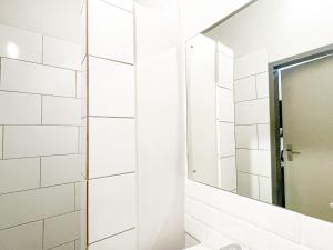 a bathroom with a mirror and white tiles at Cosy Home away from home in Johannesburg