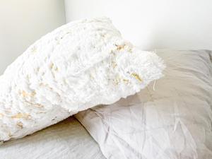 a bed with a white pillow with crumbs on it at Cosy Home away from home in Johannesburg
