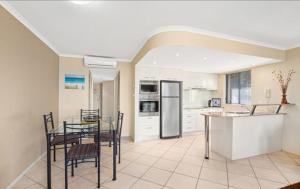 eine Küche mit Tisch und Stühlen in einem Zimmer in der Unterkunft Oceanview 1 in Nambucca Heads