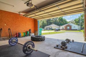 a gym with dumbbells on the floor in a garage at Verb - Arcades, Grill, Gym, Piano, Pong, & Beach! in Fort Walton Beach