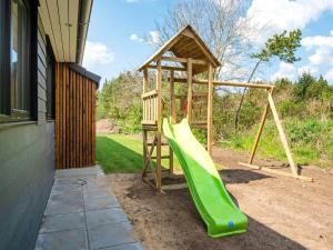 a playground with a green slide next to a building at Luxury Retreat with Pool - By Traum Ferienwohnungen in Oksbøl
