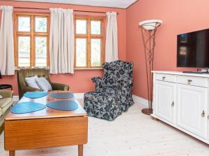 ein Wohnzimmer mit einem Tisch und einem TV in der Unterkunft Holiday home Grenaa XLVIII in Grenå