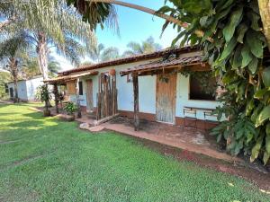a small house with a grass yard in front of it at Pousada Fazenda São Pedro in Delfinópolis
