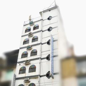 a tall white building with a blue tie on it at Hotel Hoque Tower International in Chittagong