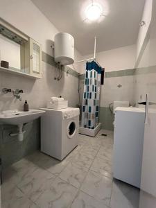 a bathroom with a washing machine and a sink at Apartment Nela in Brna