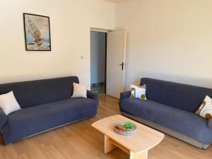 a living room with two blue couches and a table at Apartment Nela in Brna