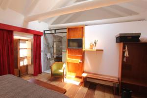 1 dormitorio con 1 cama y TV en una habitación en ARQUEOLOGO EXCLUSIVE SELECTION - Casa Peralta, en Cusco