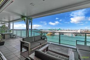 a living room with a couch and a view of the water at QV Upmarket Waterfront Apartment - 787 in Auckland