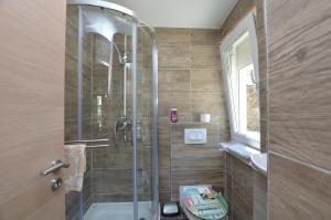 a bathroom with a shower with a toilet and a sink at Apartments Bela in Lovran