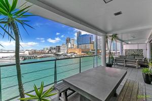 einen Balkon mit einem Tisch und Blick auf das Wasser in der Unterkunft QV Upmarket Waterfront Apartment - 787 in Auckland