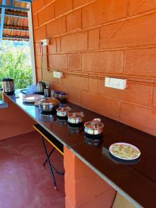 un mostrador con ollas, sartenes y platos de comida. en FernHills Homestay, en Madikeri