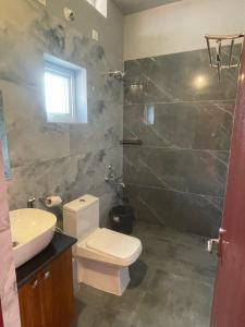 uma casa de banho com um WC e um lavatório em FernHills coorg em Madikeri