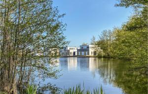 a large building sitting on top of a lake at Beautiful Home In Tossens With Lake View in Tossenserdeich