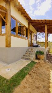 a house with stairs in front of it at Sitio Boa Fé - 300m das cachoeiras Moinho e Salomão in Carrancas