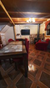 een woonkamer met een houten tafel en rode stoelen bij Normita cabaña in Villa Cerro Castillo