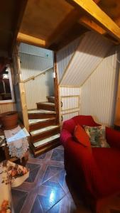 een woonkamer met een rode bank en een trap bij Normita cabaña in Villa Cerro Castillo
