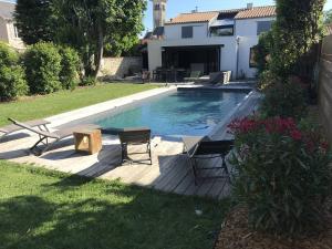 拉羅歇爾的住宿－Villa La Rochelle, 7 pièces, 10 personnes - FR-1-710-5，庭院内一个带两把椅子和一张桌子的游泳池