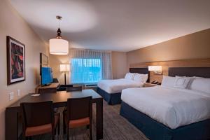 a hotel room with two beds and a desk at TownePlace Suites by Marriott Tacoma Lakewood in Lakewood