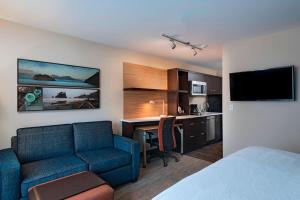 a hotel room with a couch and a desk and a kitchen at TownePlace Suites by Marriott Tacoma Lakewood in Lakewood
