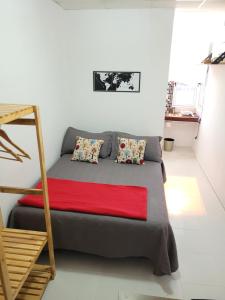 a bedroom with a bed with a red blanket at Departamento - M I N I D O in Resistencia