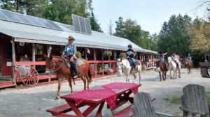 TehkummahK!cking Mule Guest Ranch的一群骑马的人围着桌子骑着马