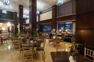 um restaurante com mesas e cadeiras num edifício em Bayview Park Hotel Manila em Manilla