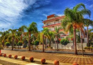duży budynek z palmami przed nim w obiekcie Hotel Carmen Teresa w mieście Torremolinos