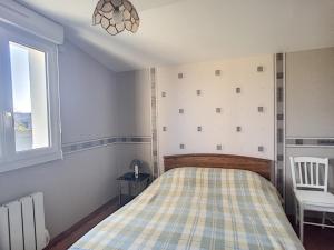 a bedroom with a bed and a chair and a window at Maison paisible proche de la plage avec jardin et équipements complets - FR-1-361-491 in Carolles