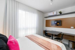 a bedroom with a bed and a desk and a table at Housi Brickell One - HBO0207 in Curitiba
