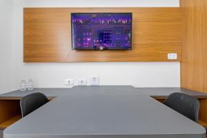 - une salle de conférence avec une table et une télévision murale dans l'établissement Housi Brickell One - HBO0306, à Curitiba