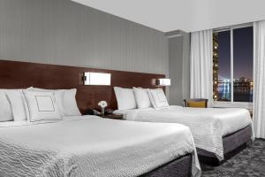 紐約的住宿－紐約曼哈頓庭院酒店/上東區，酒店客房设有两张床和窗户。