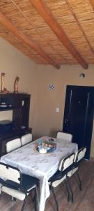 mesa de comedor con sillas y mantel blanco en Cabaña la Encantada en Humahuaca