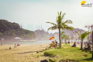 un grupo de personas en una playa con una cometa en Pousada Elegance Beira Mar, en Itanhaém