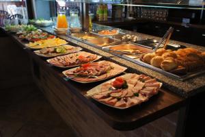a buffet line with many plates of food and bread at Pensjonat Amber in Pobierowo