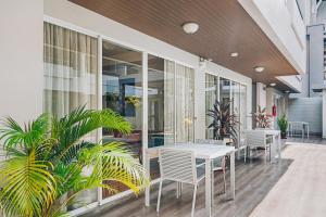 patio ze stołem, krzesłami i roślinami w obiekcie Chateau Dale Boutique Resort Spa Villas w Pattaya South