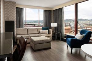 een woonkamer met een bank en stoelen en een balkon bij Colorado Springs Marriott in Colorado Springs