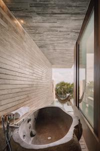 a large bath tub in a bathroom with a window at La Casa de la Playa by Xcaret- All Inclusive Adults Only in Playa del Carmen