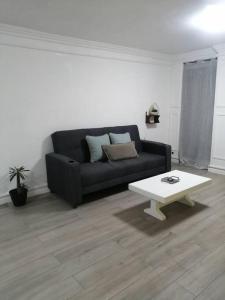 uma sala de estar com um sofá preto e uma mesa de centro em Disfruta de cómodo y bello departamento em Guadalajara