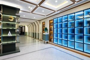 uma sala de vestir com paredes de vidro azul e um corredor em Nostalgia Hotel S - Beijing National Convention Center em Pequim