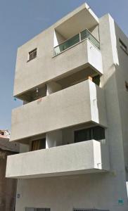 a large concrete building with a balcony at Loft amazing Grazie Boutique in Tel Aviv