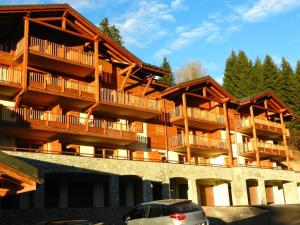 a large wooden building with balconies and a car parked in front at Appartement Crest-Voland, 5 pièces, 8 personnes - FR-1-733-123 in Crest-Voland