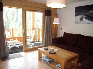 a living room with a couch and a table and a balcony at Appartement 8 personnes, piscine, wifi, 4 ch, parking - FR-1-733-123 in Crest-Voland