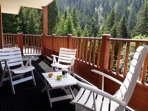 a deck with white chairs and a table with a view at Appartement 8 personnes, piscine, wifi, 4 ch, parking - FR-1-733-123 in Crest-Voland