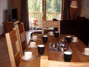 drewniany stół z talerzami i kubkami oraz czajnik do herbaty w obiekcie Appartement Crest-Voland, 5 pièces, 8 personnes - FR-1-733-123 w mieście Crest-Voland