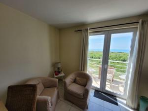 a living room with two chairs and a large window at Duplex 2 Chambres avec Parking et Animaux Admis - FR-1-675-22 in Wimereux