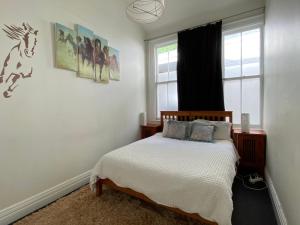 a bedroom with a bed and a window at Beach front House in Wellington
