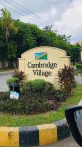 a sign for a canberraurance village on the side of a road at StayinManila in Pasig